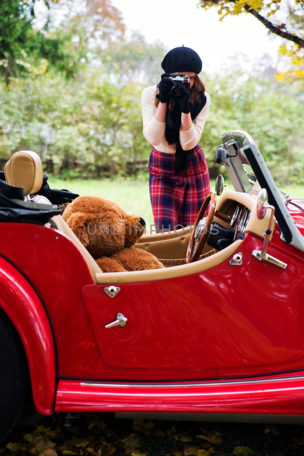 Woman take photo of toy at retro car