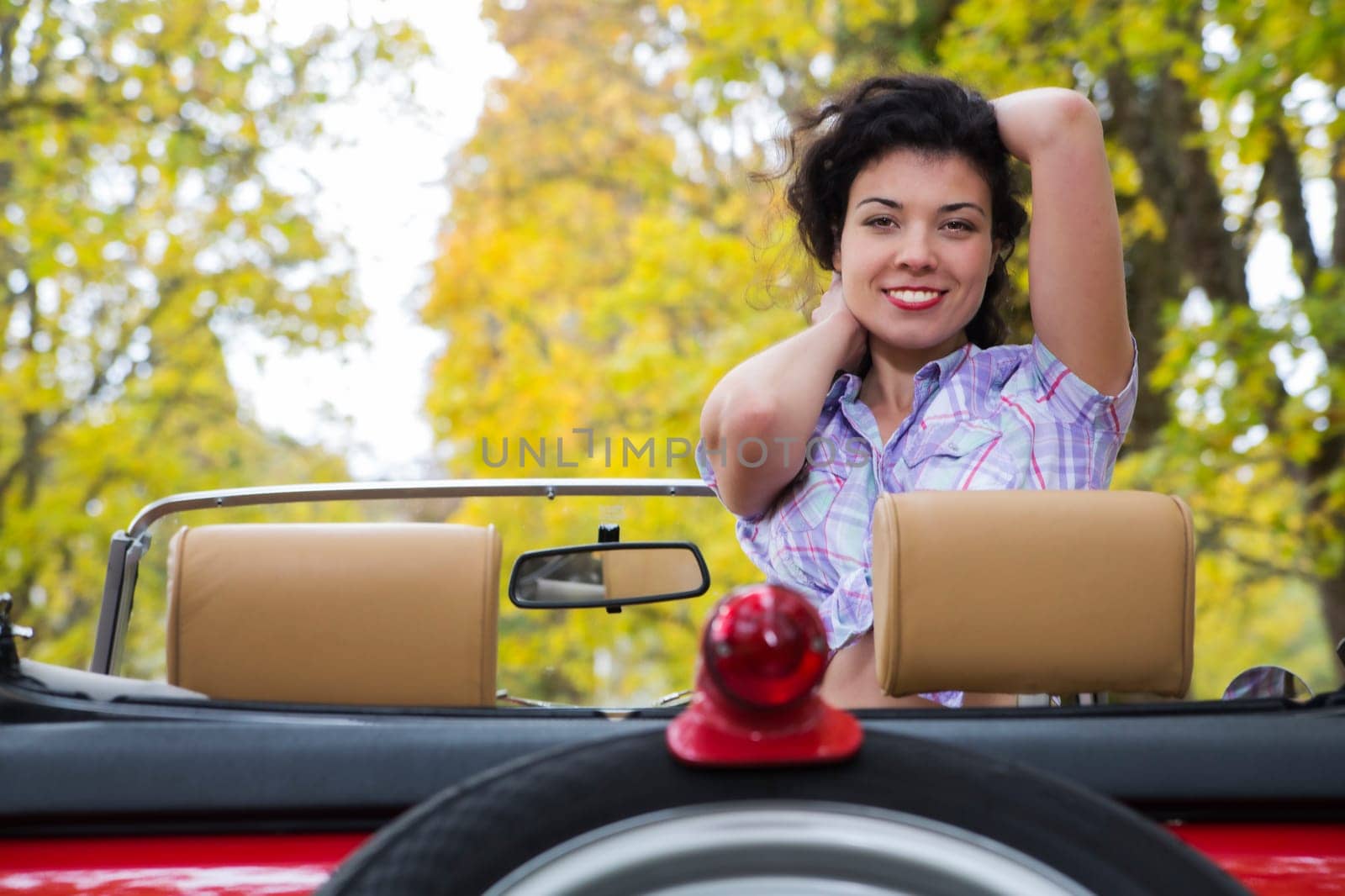 Amazing woman with wide smile at retro car