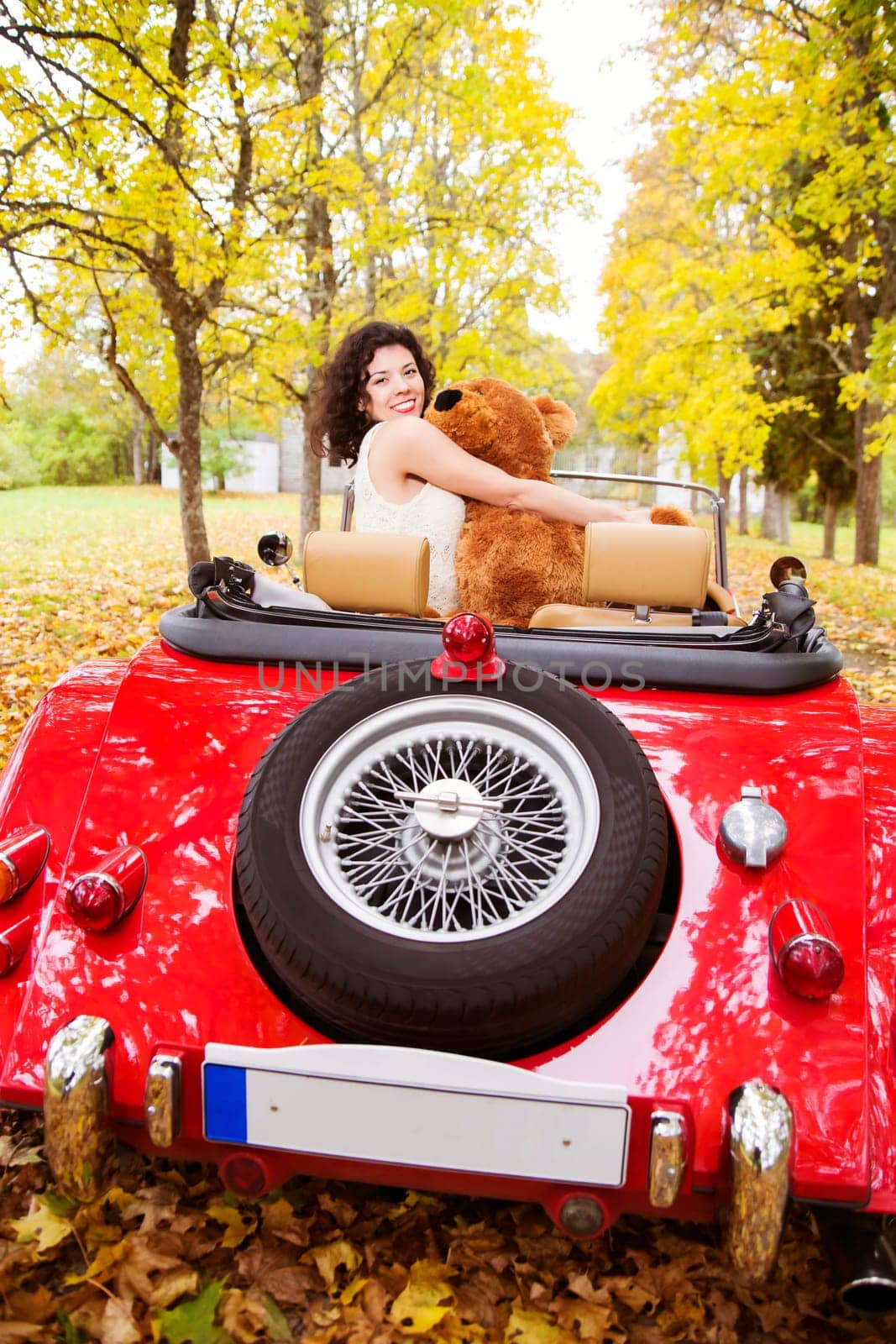 Happy woman puddle toy at car at park