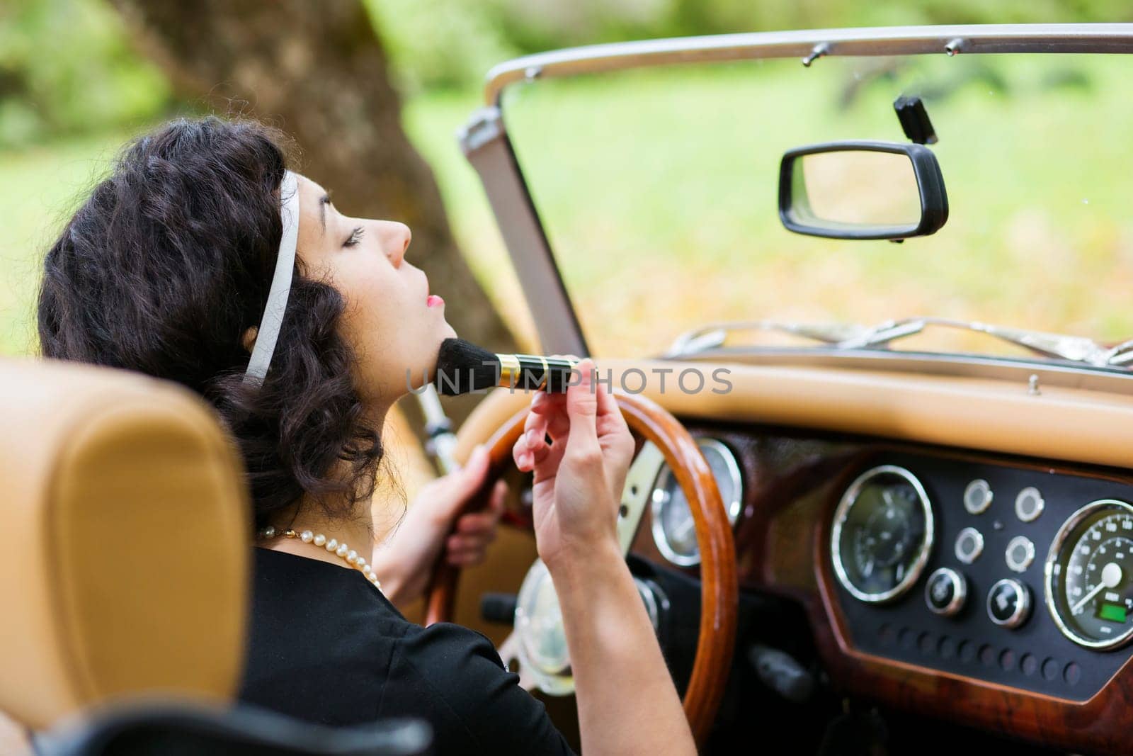 Woman adjust face before mirror at driver seat