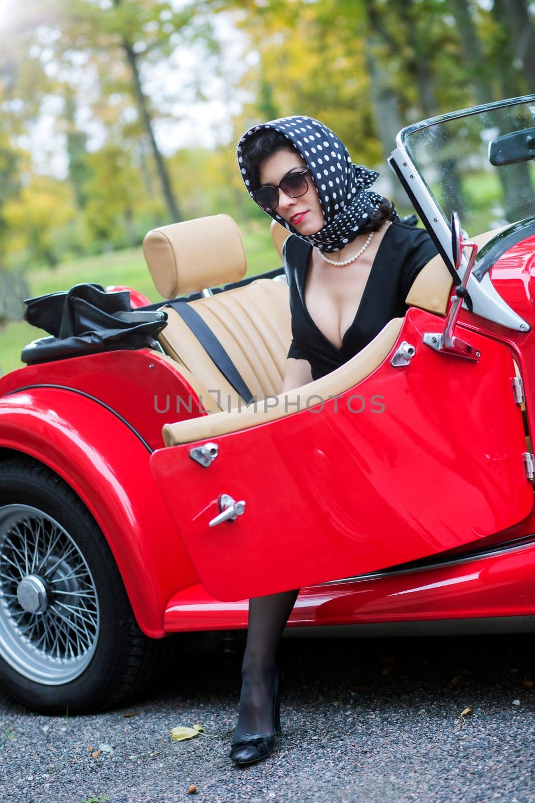 Satisfied woman in black and opened car door