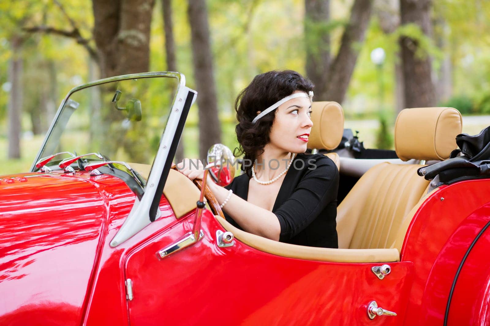 Pretty woman hold car wheel and look back