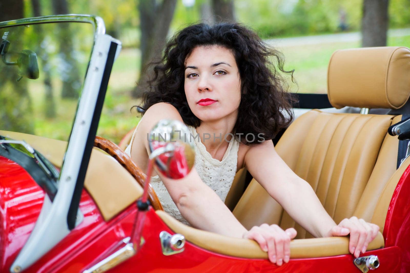 Serious look woman look out of retro car