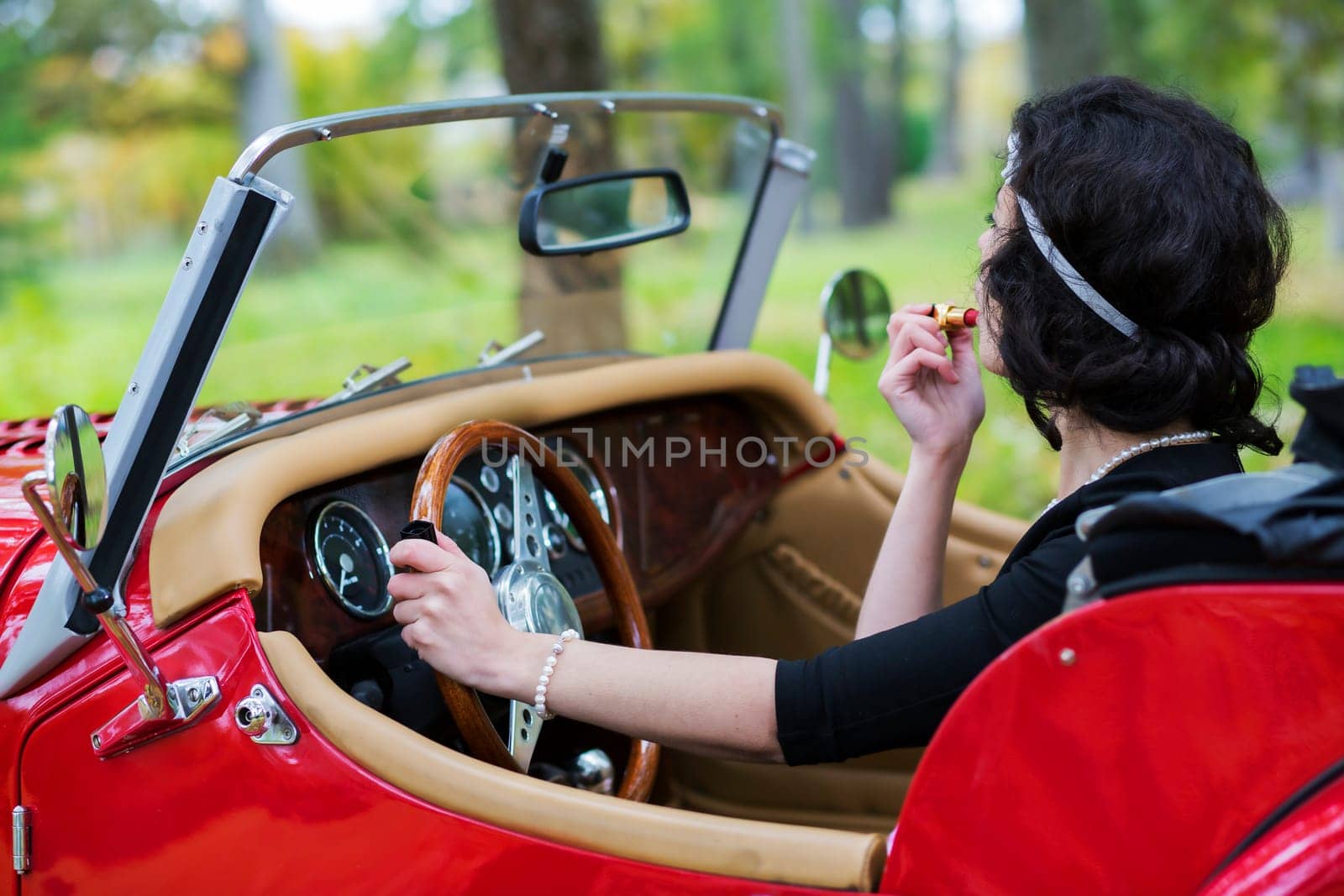 Pretty woman stains the lips and hold wheel