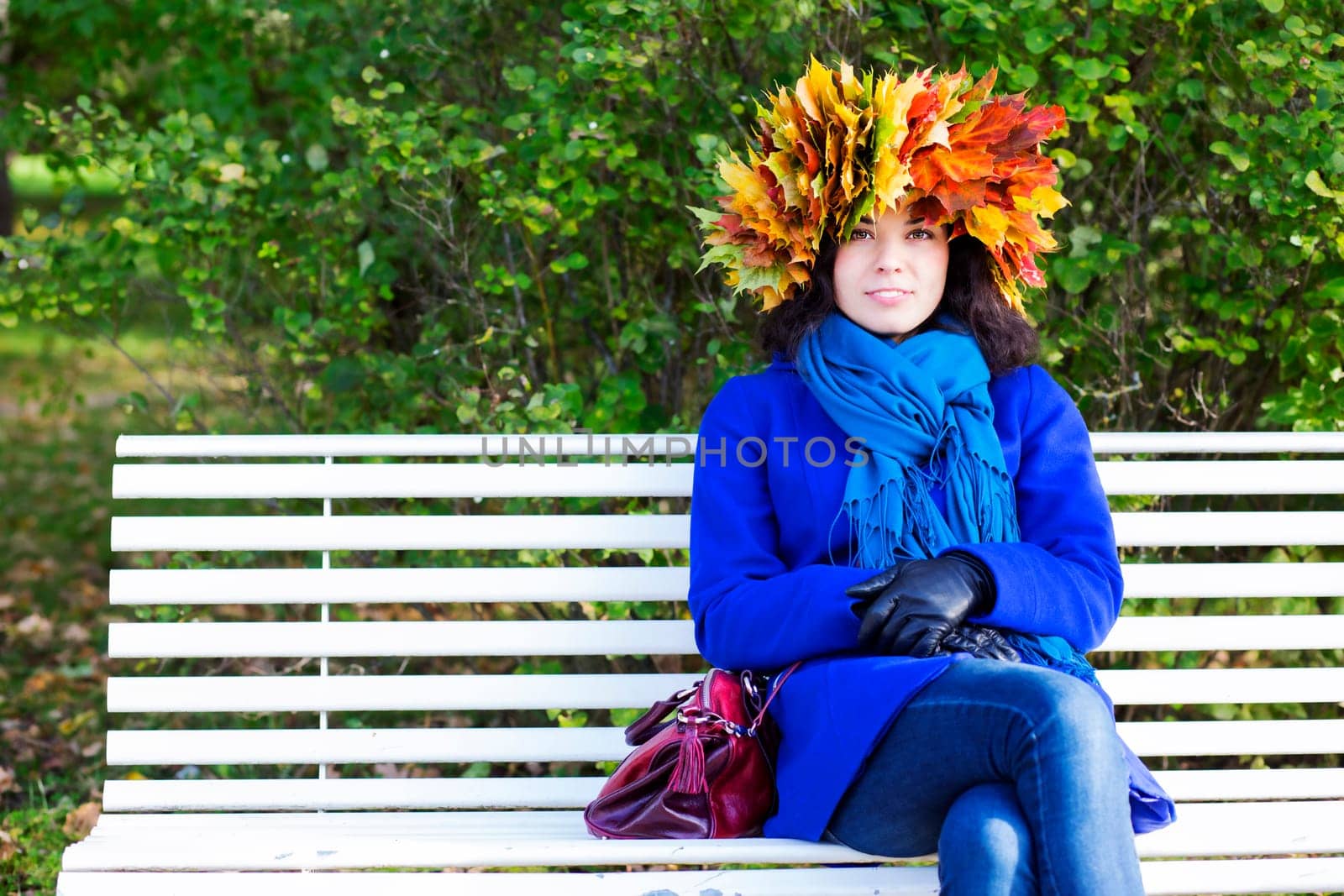 Satisfied young woman with maple leaves on head