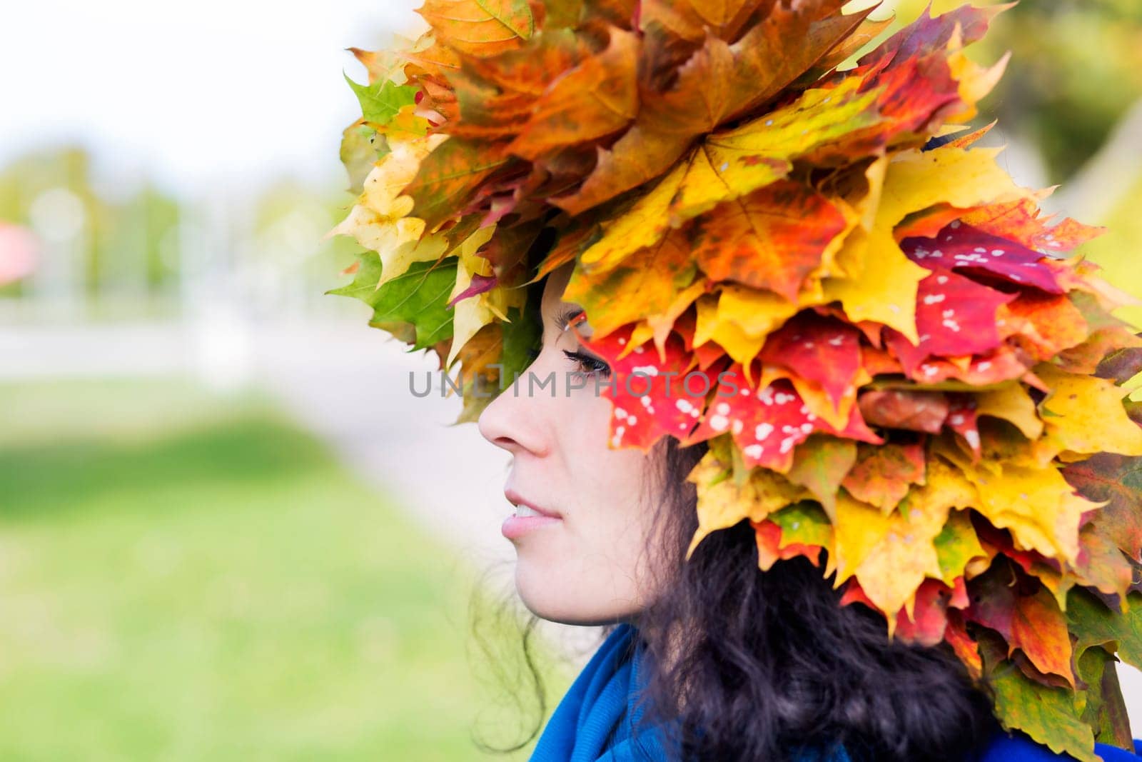 Woman with maple leaves on head from side
