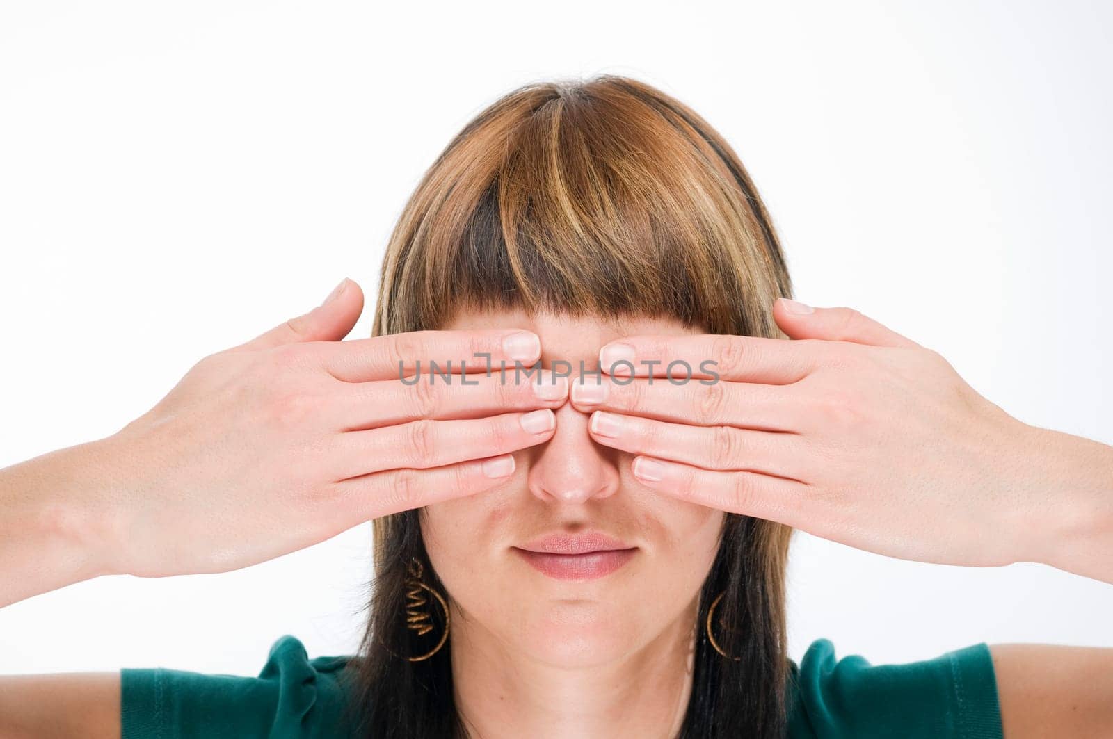 Head-and-shoulder view of a young woman looking into the camera and covering her eyes  Gesture