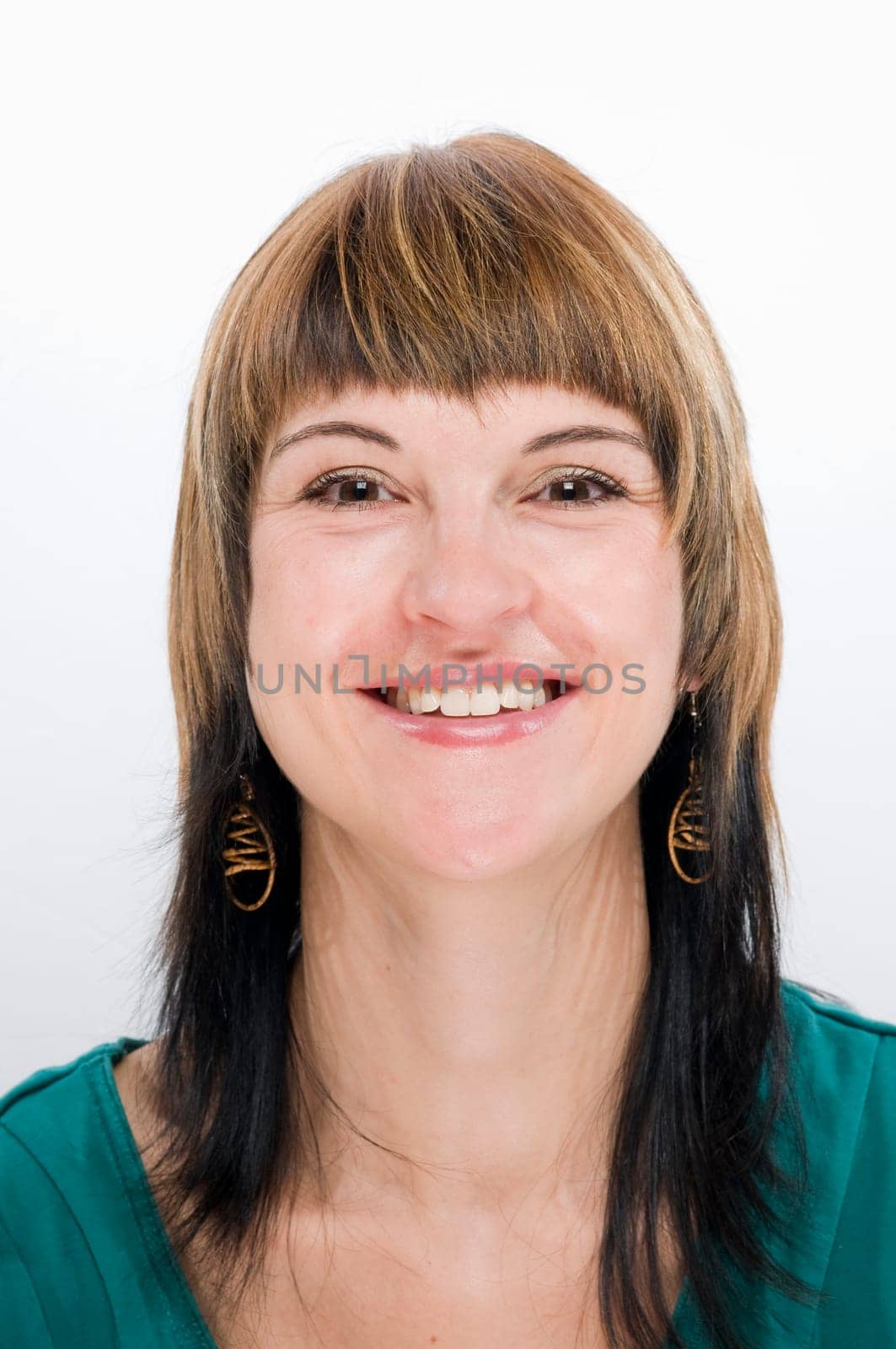 Head-and-shoulder shot of a young woman with a beaming,happily smiling look into the camera