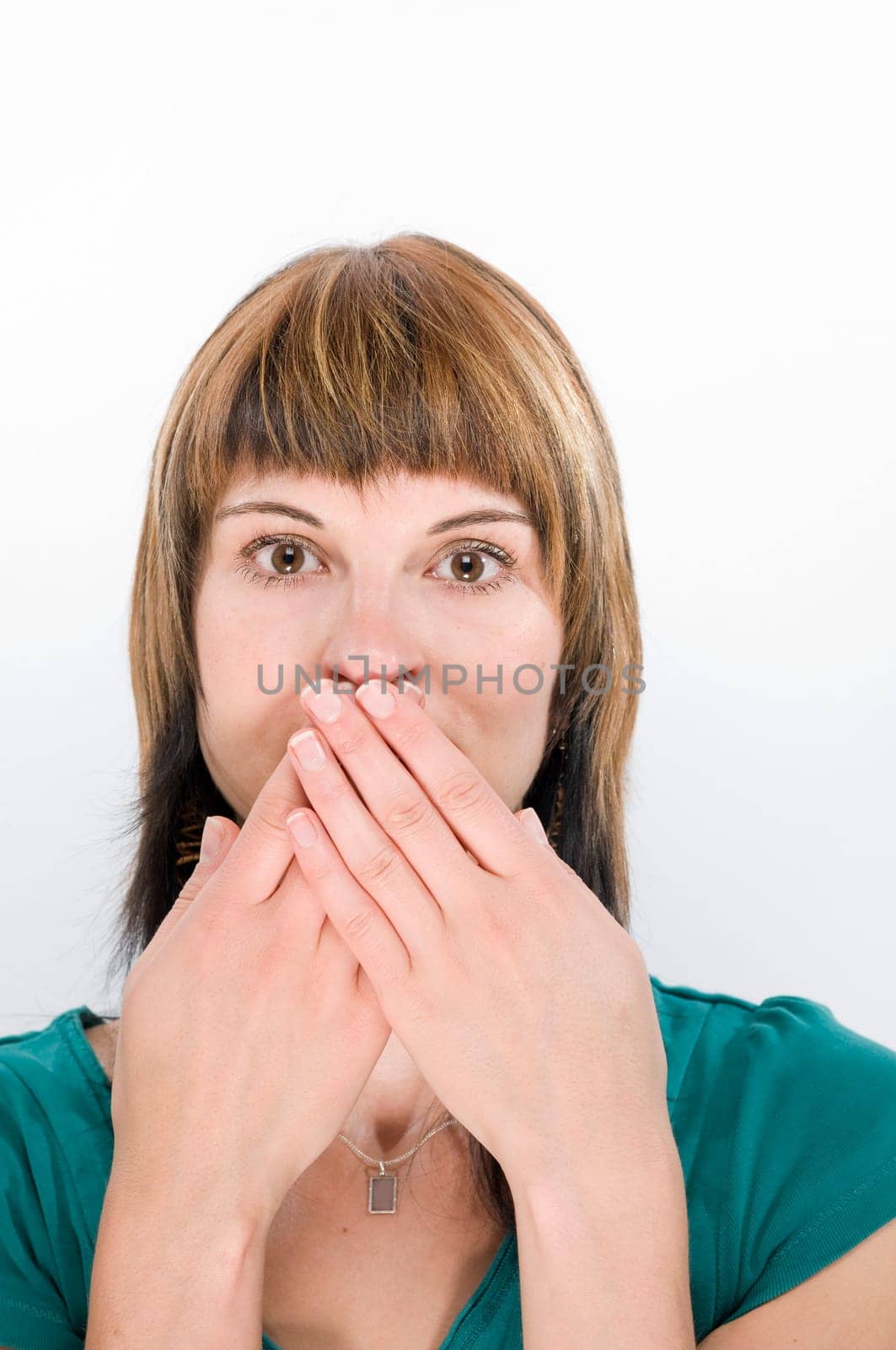 Head-and-shoulder view of a young woman looking into the camera and covering her mouth  Gesture