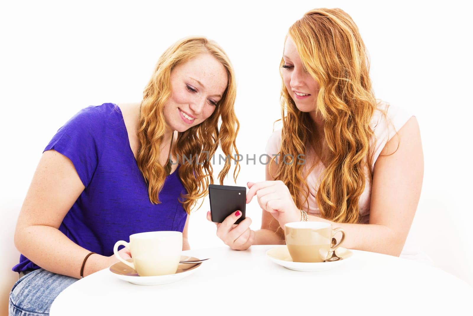 Young women having coffee looking at their smartphone against a white background