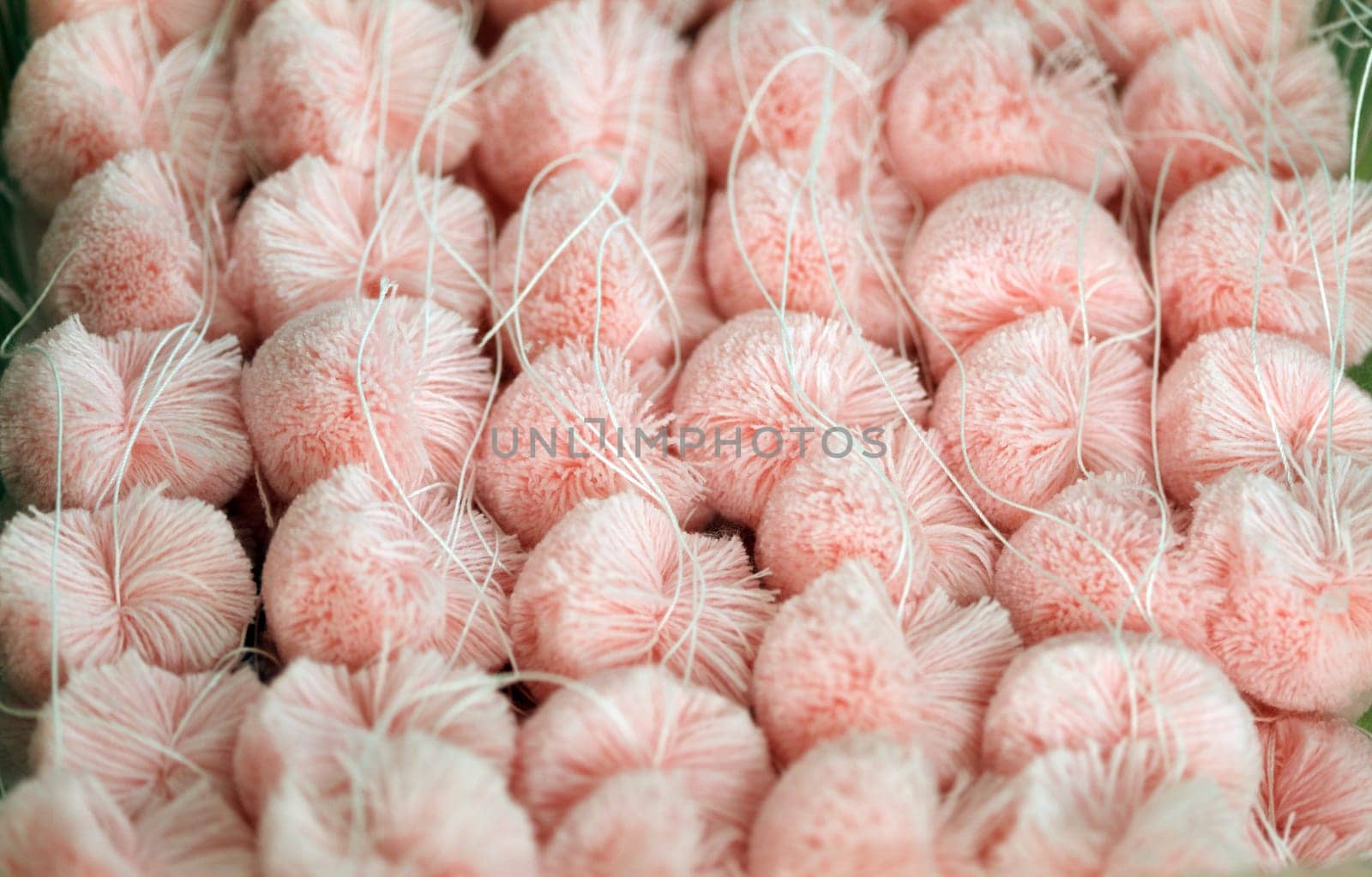 Fluffy pink pompoms for baby clothes, close-up