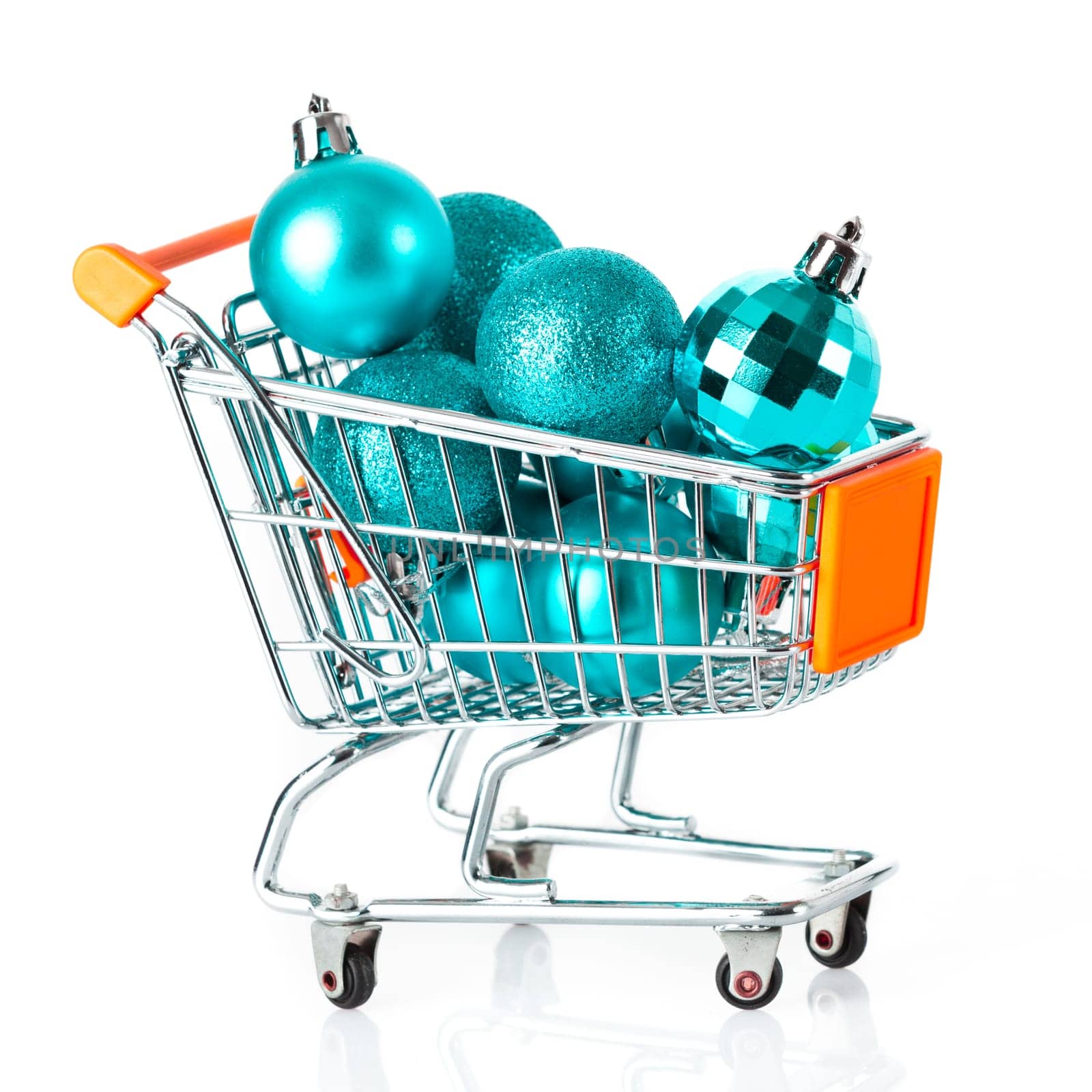 Shopping cart full of christmas balls isolated on white background