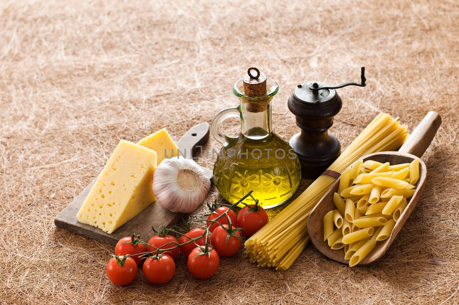 Raw pasta spaghetti, tomatos and cheese, on wooden table