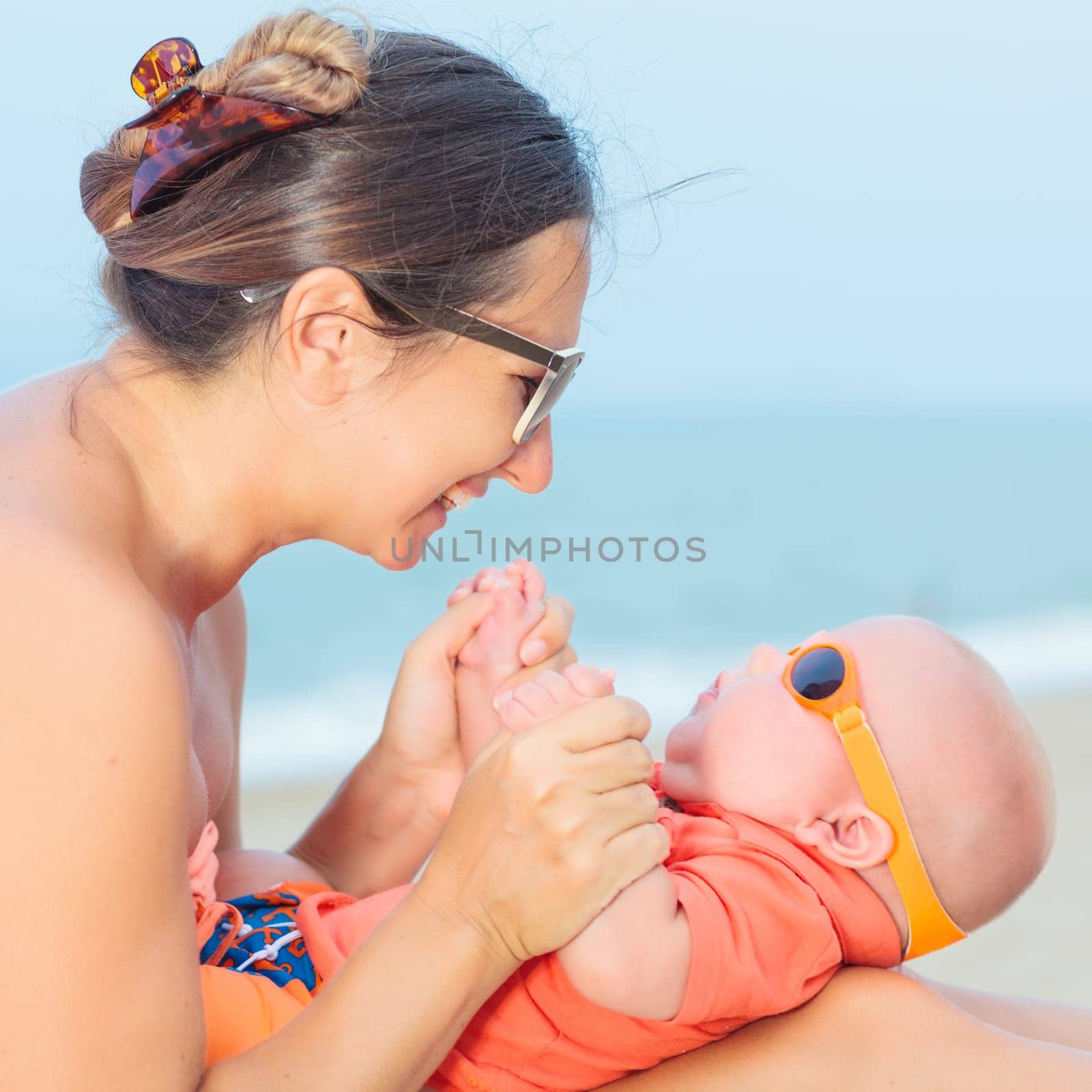 Baby and mom are relaxing on sunbed