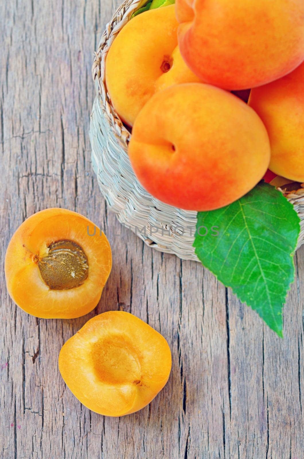 apricot fruits with green leaf and cut isolated on wooden background