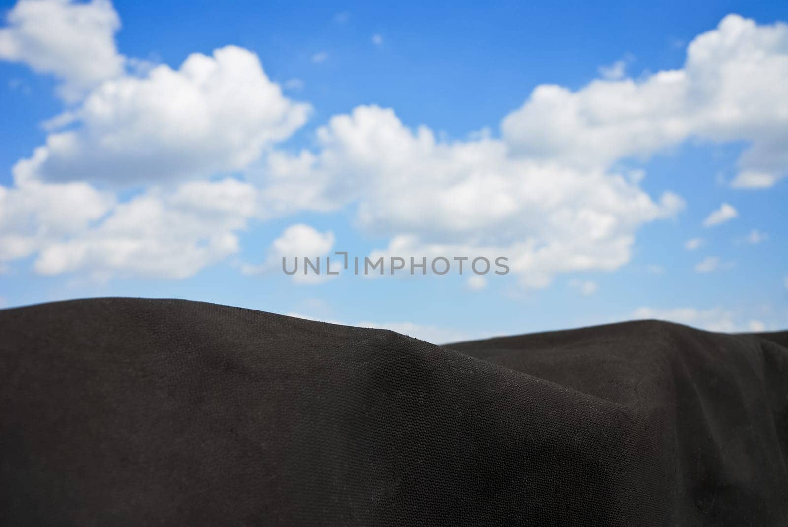 Black tarpaulin with sky and clouds
