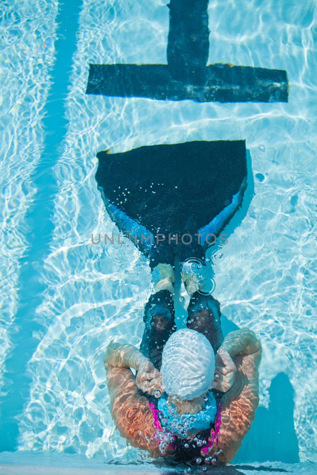 Female freediver with monofin concentrating and preparing at edge swimming pool