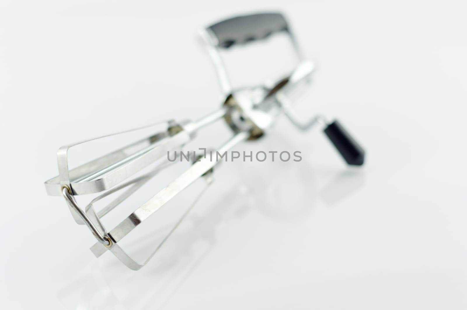 Old hand mixer made of metal with white background