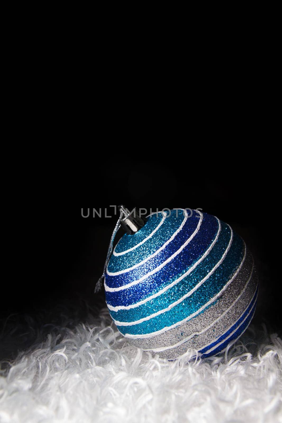 Blue christmas balls white fur background.
