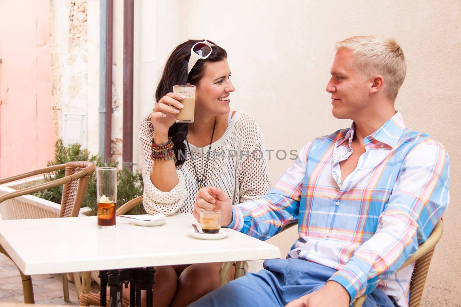 Young attractive couple in a café in summer chatting holiday leisure