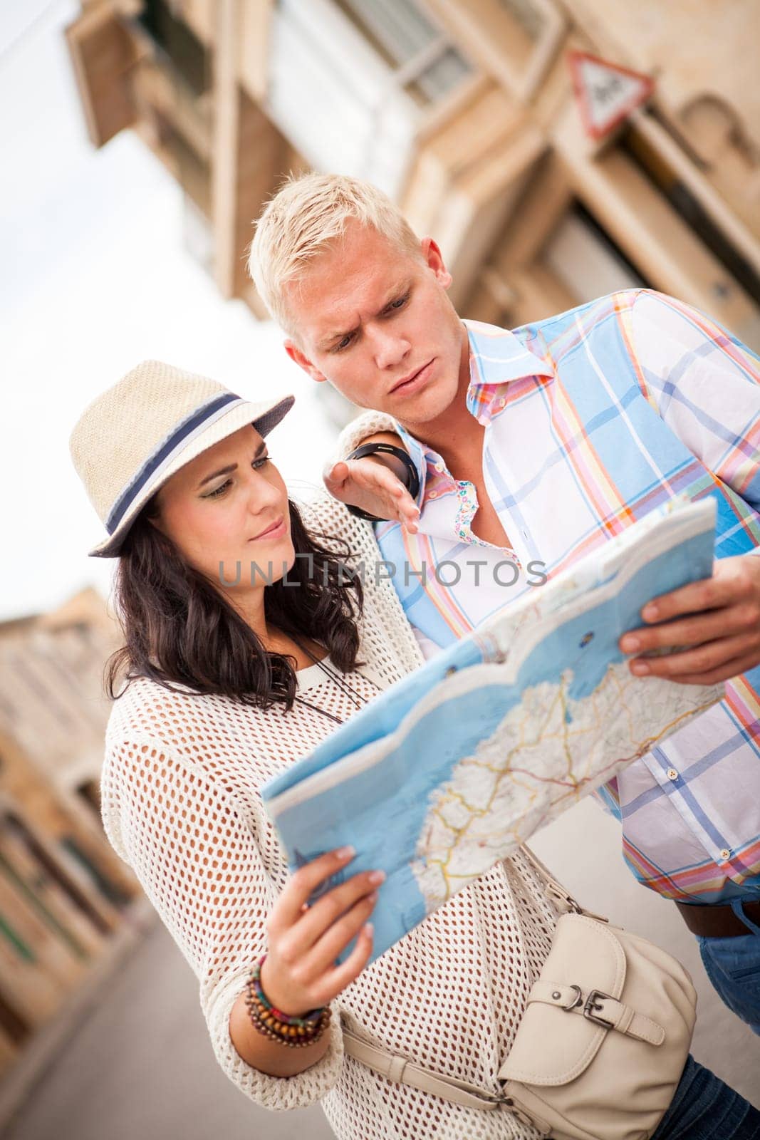 Young tourist couple in summer with map in the city travel tour