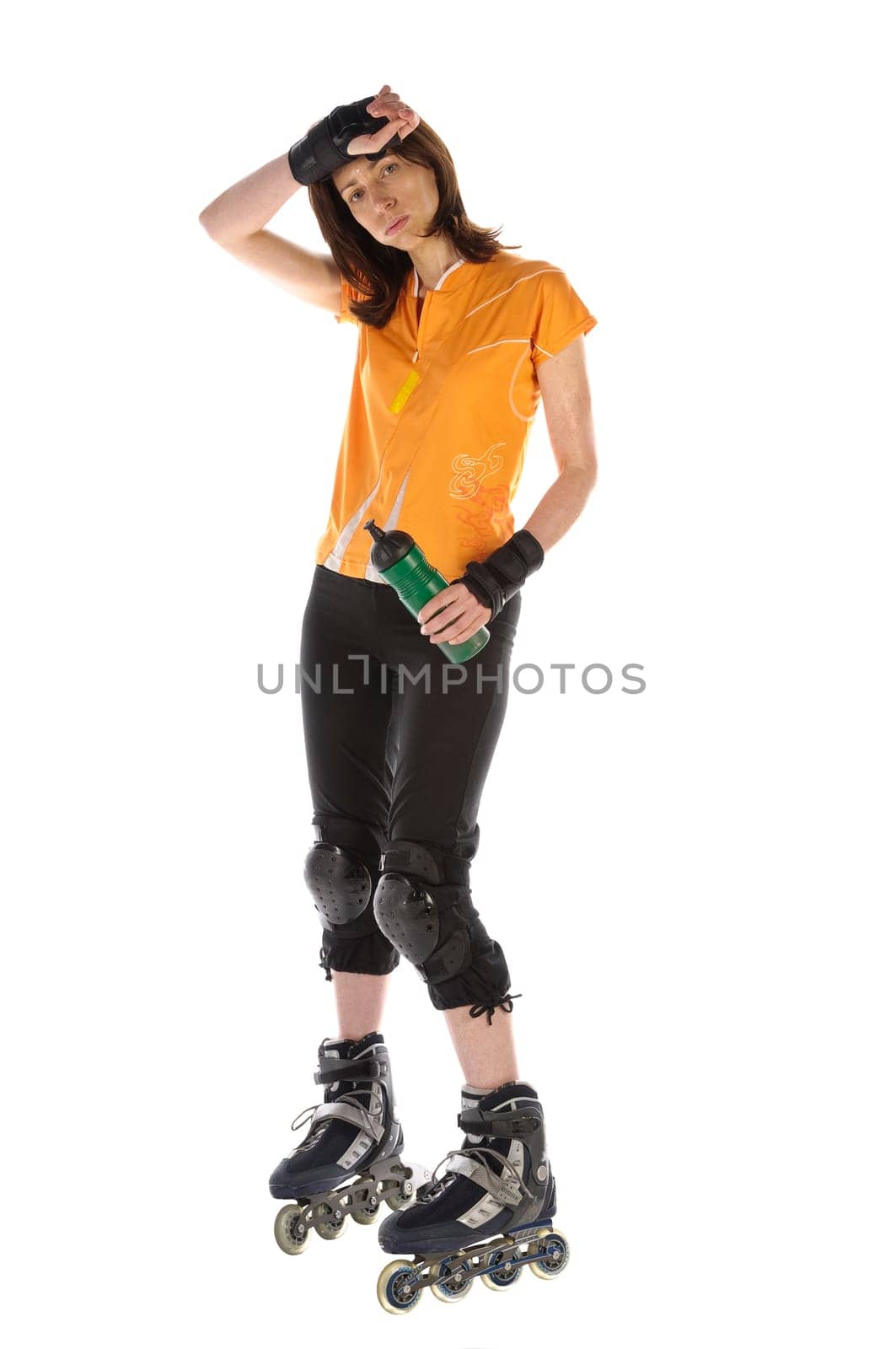 Adult woman does sports on inline skates and drinks from her water bottle against a white background