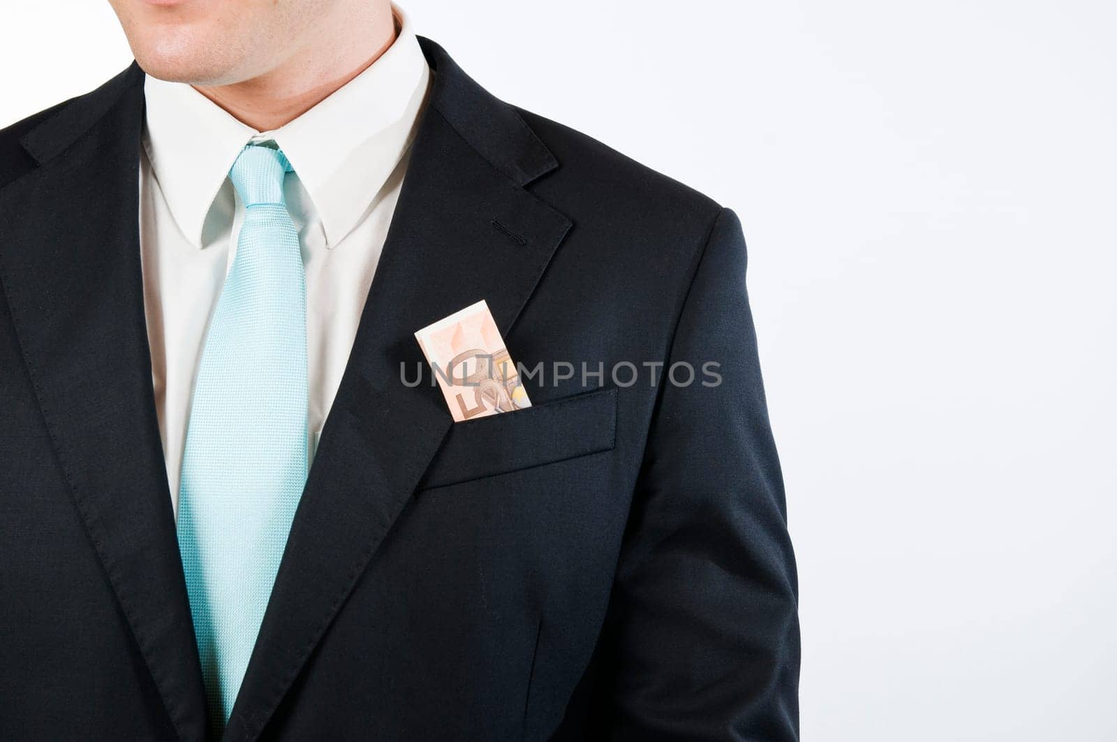 Upper body view without head of a young man in a black suit against white background with folded dollar bill outstanding from the outer chest pocket.
