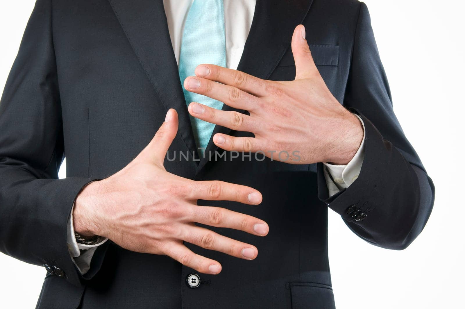 Chest-and-stomach view of a young man in a black suit with his hands held in front of him indicating the "10"" (ten fingers)"