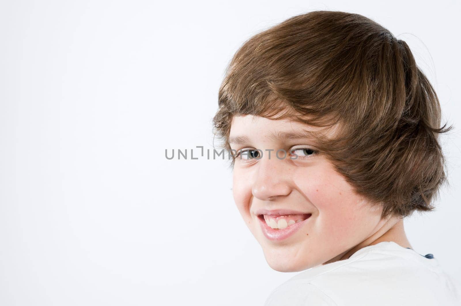 Head and shoulders portrait of a male teenager against white background.