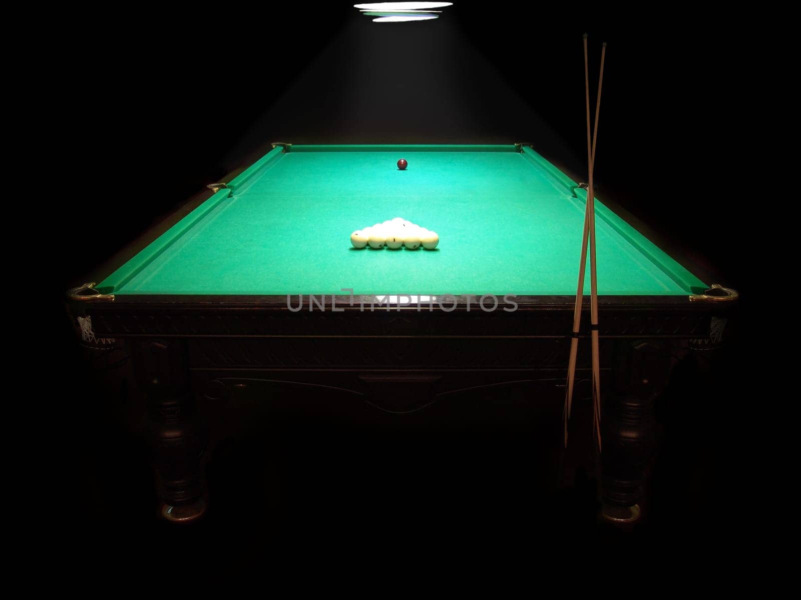 The russian billiard table with a cue and balls on a dark background
