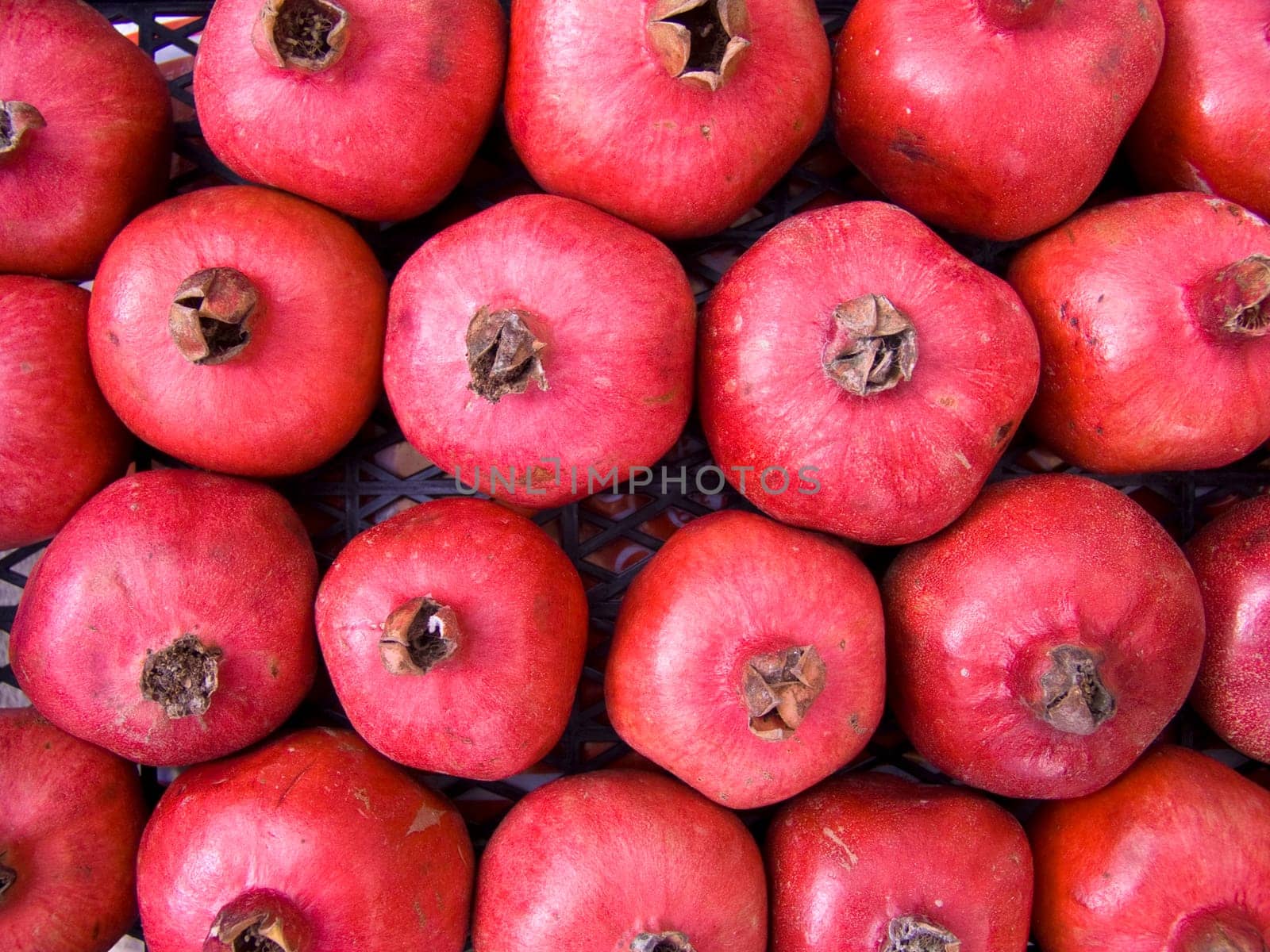 A pile of beautiful  pomegranates on a counter