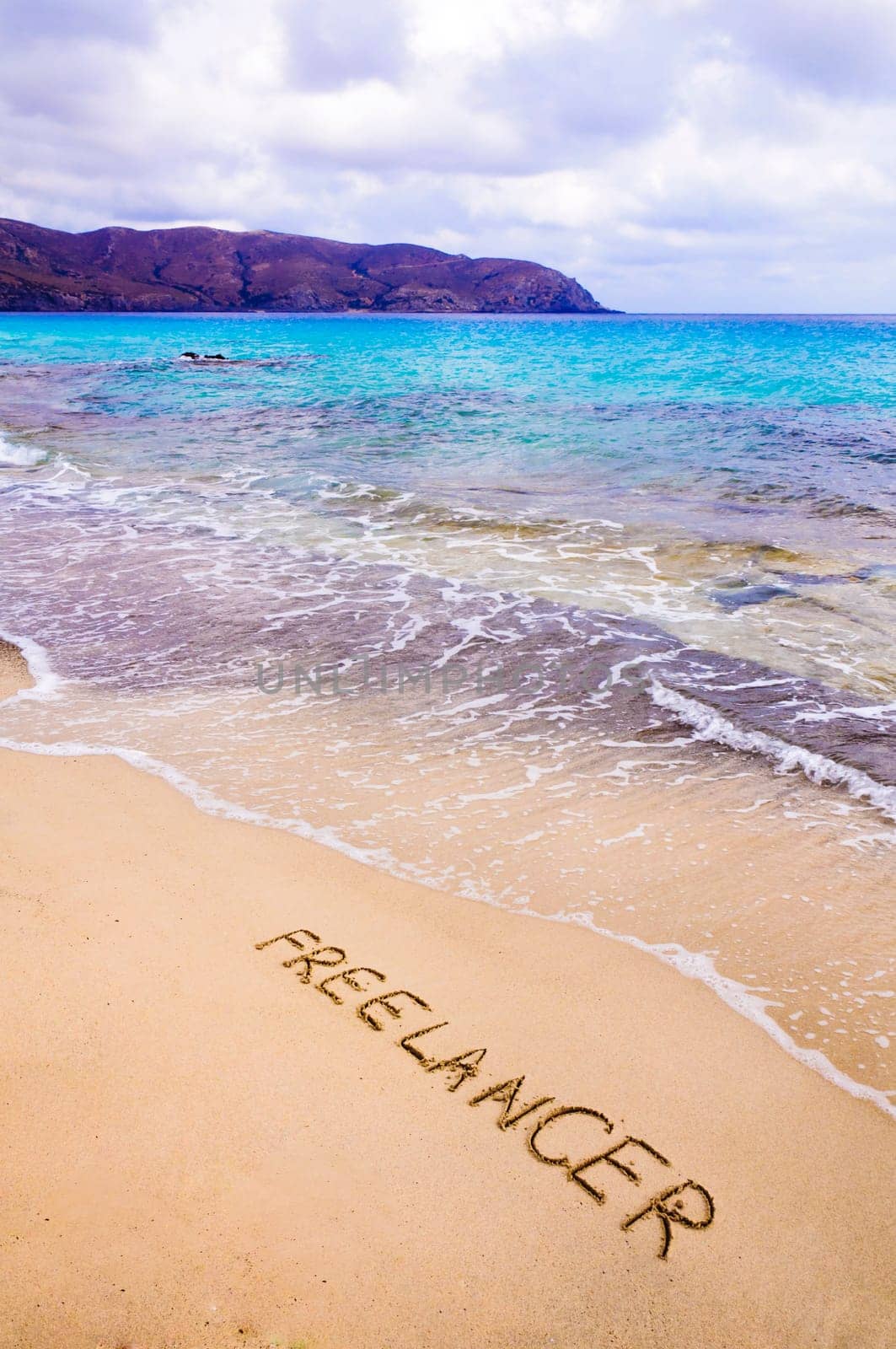 Word FREELANCER written in sand, on a beautiful beach, Freelance concept