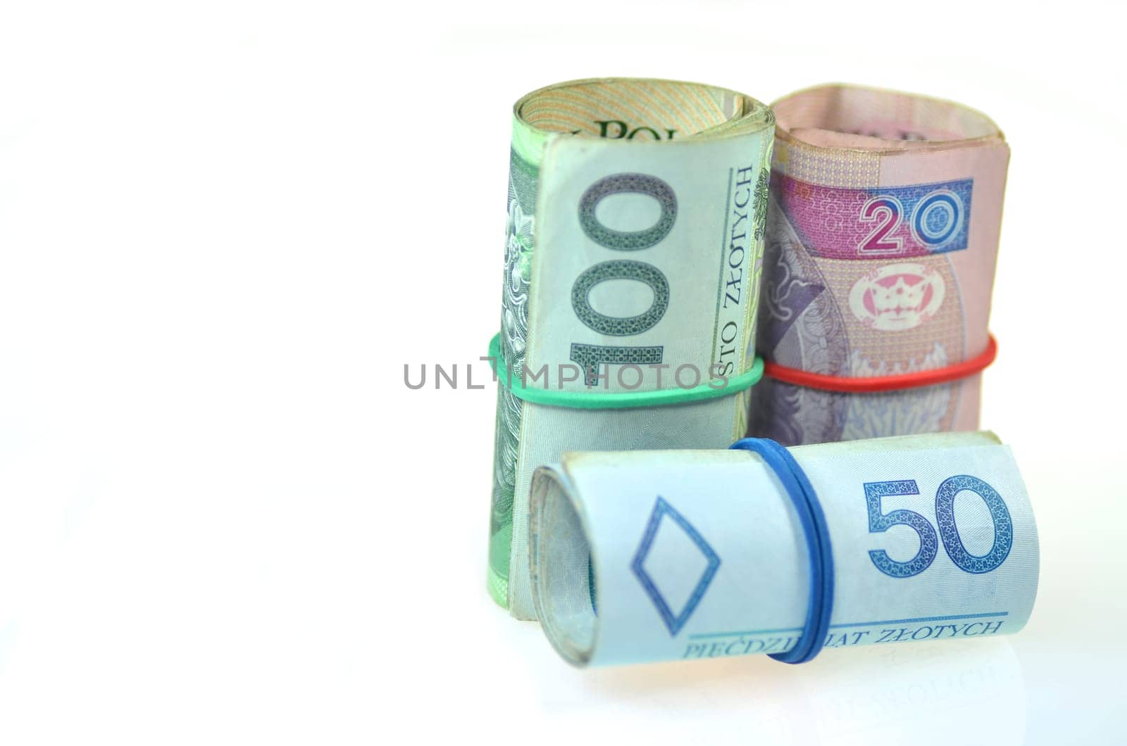 rolls of polish banknotes and coins isolated on white