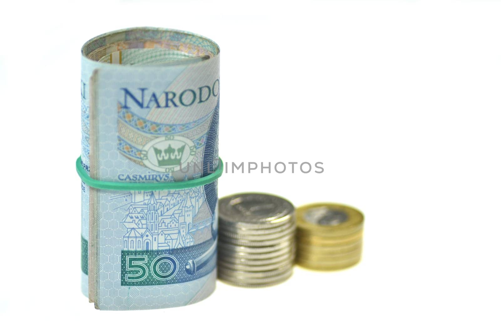rolls of polish banknotes and coins isolated on white