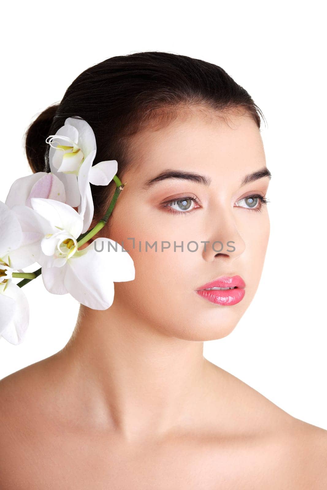 Portrait of beautiful young woman with health skin and with orchid flower