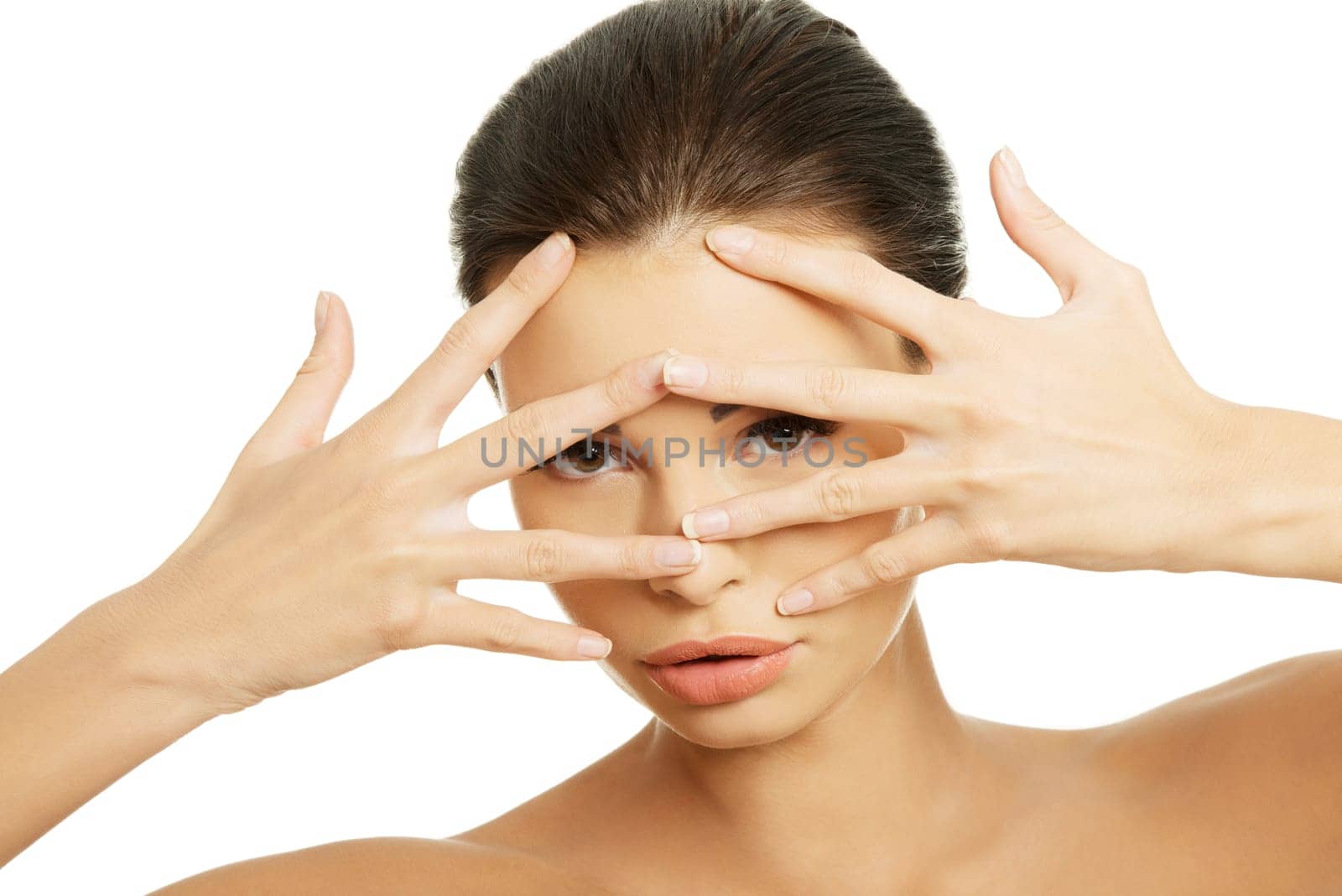 attractive female with hands on her face. spread fingers. isolated on white.