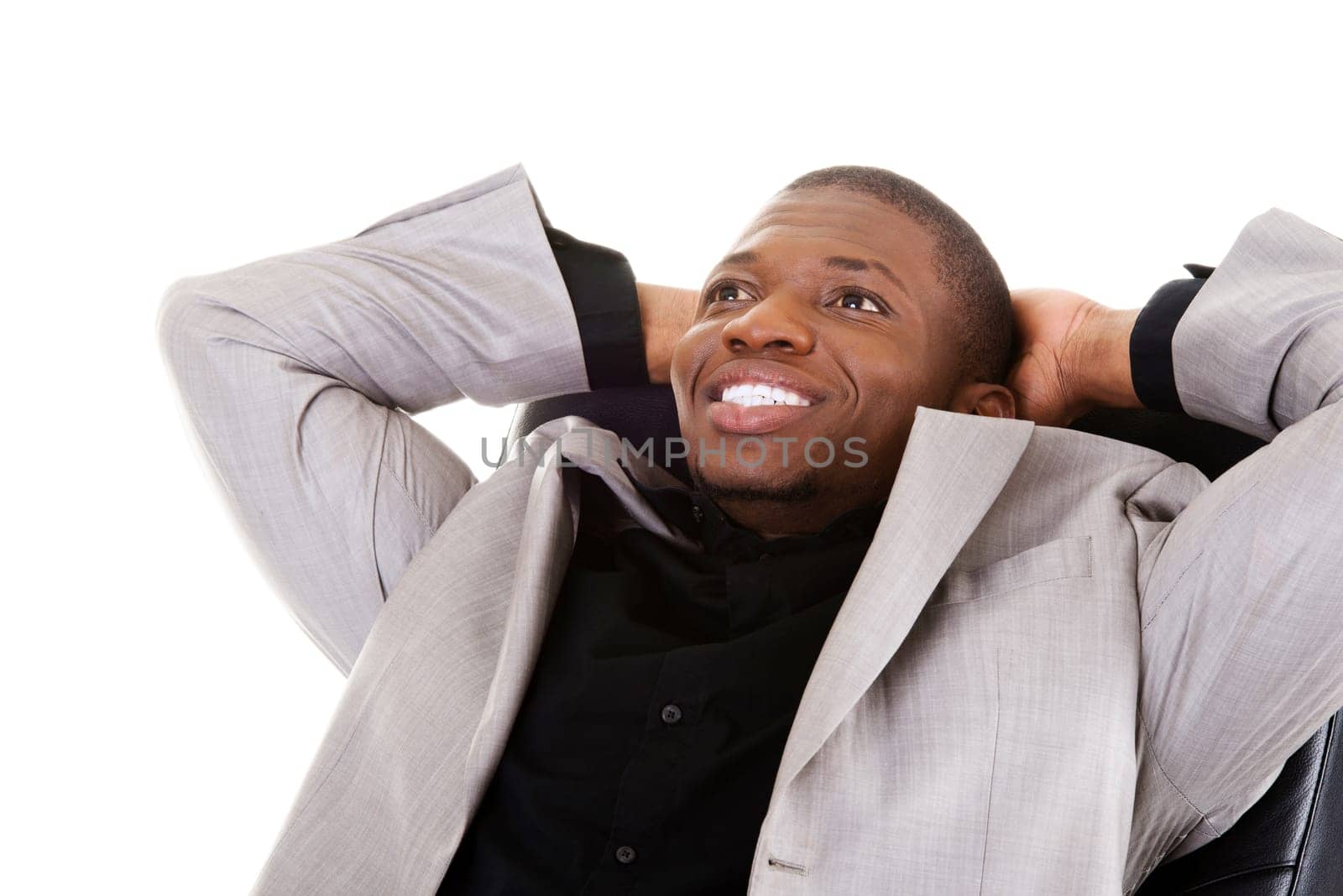 handsome businessman sitting on a chair smiling. isolated on white.