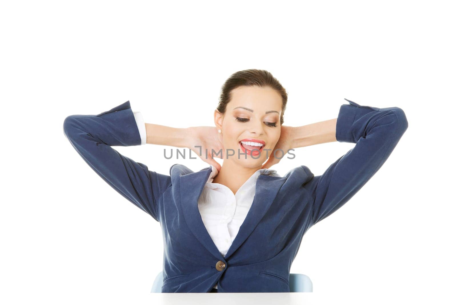 attractive woman sitting with her hands behind her neck. isolated onw hite.