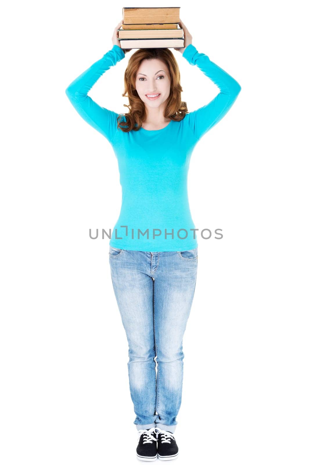 student woman holding books on her head. isolated on white.
