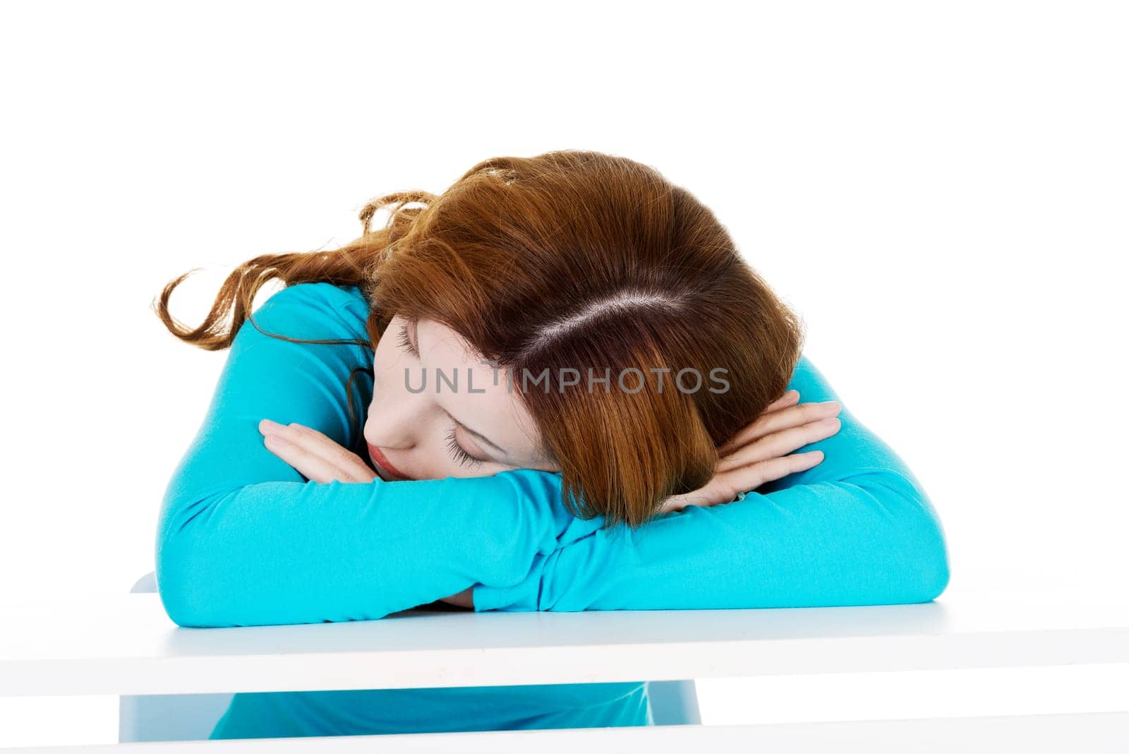 beautiful casual woman sleeping on a table. isolated on white.