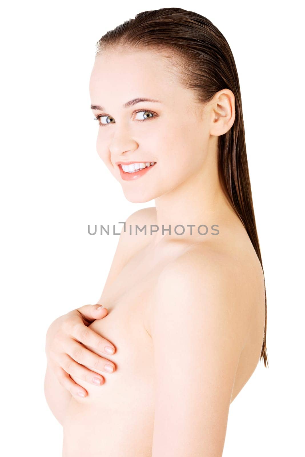 attractive young woman holding breast. front view. isolated on white.