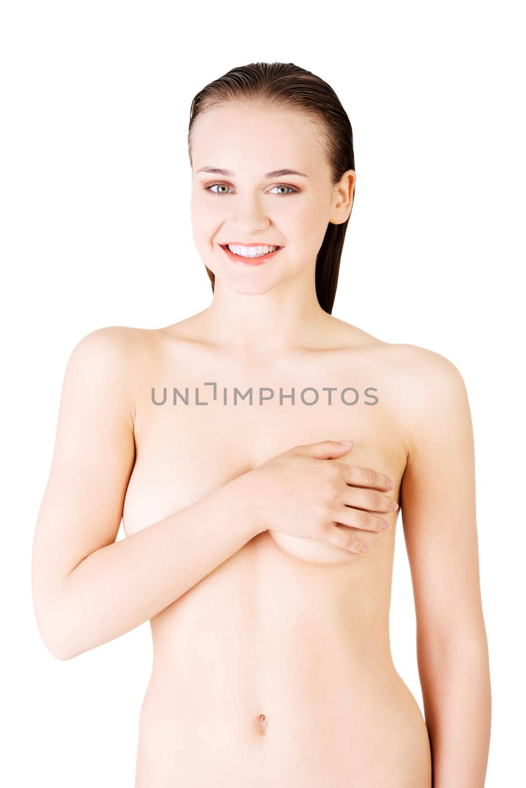 attractive young woman holding breast. front view. isolated on white.
