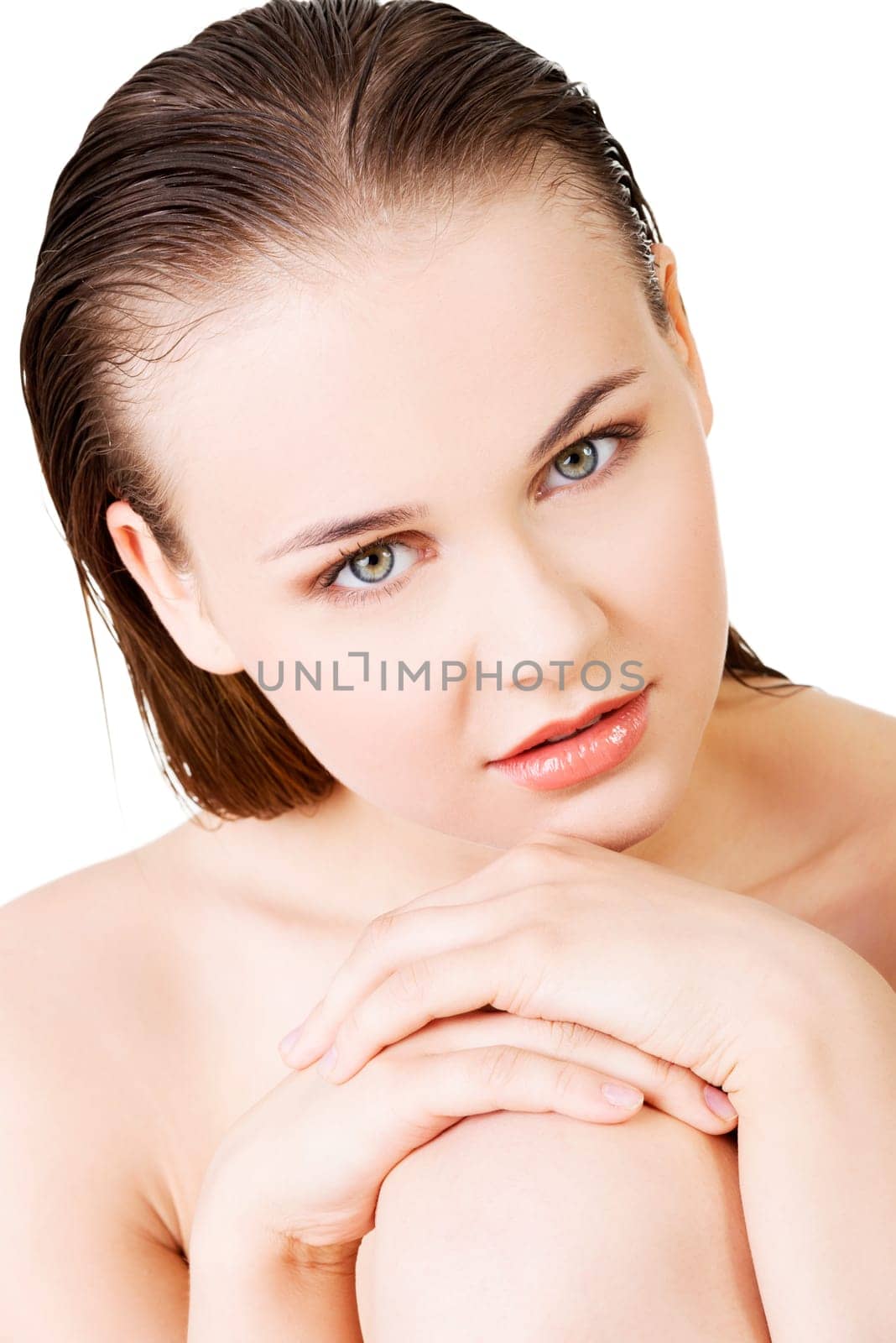 attractive young woman with wet hair. she's sitting. looking at camera. isolated on white.