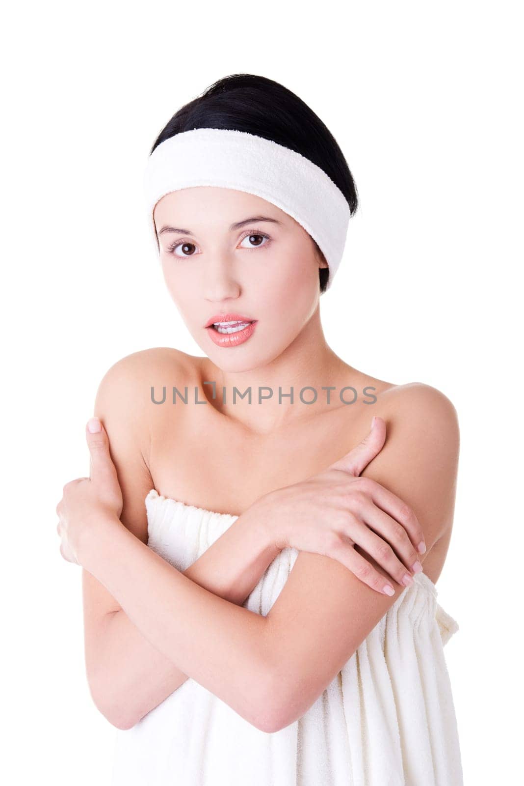 attractive woman wrapped in white towel wth headband. isolated on white.