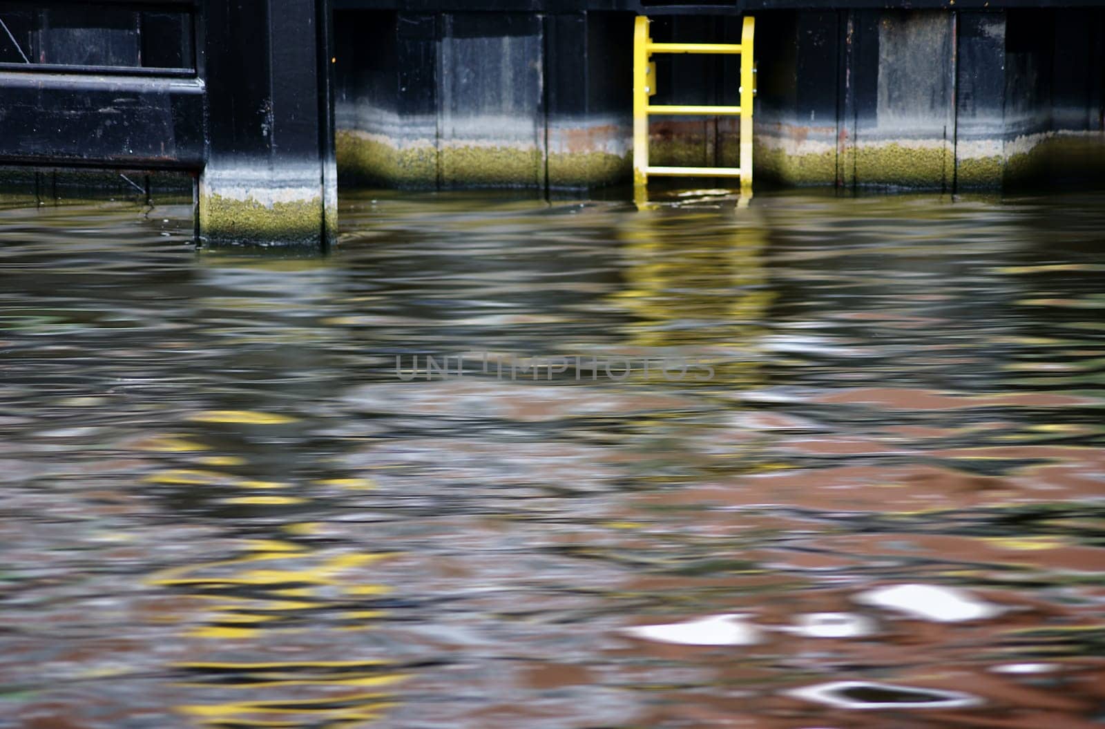 The abstract photograph and reflection of a steel quay wall in the water.