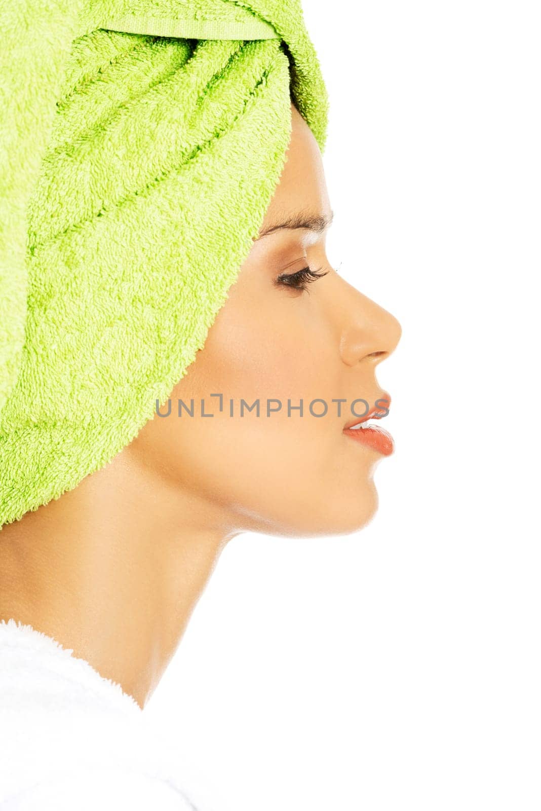 profile of attractive woman wrapped in towel with turban. isolated on white.