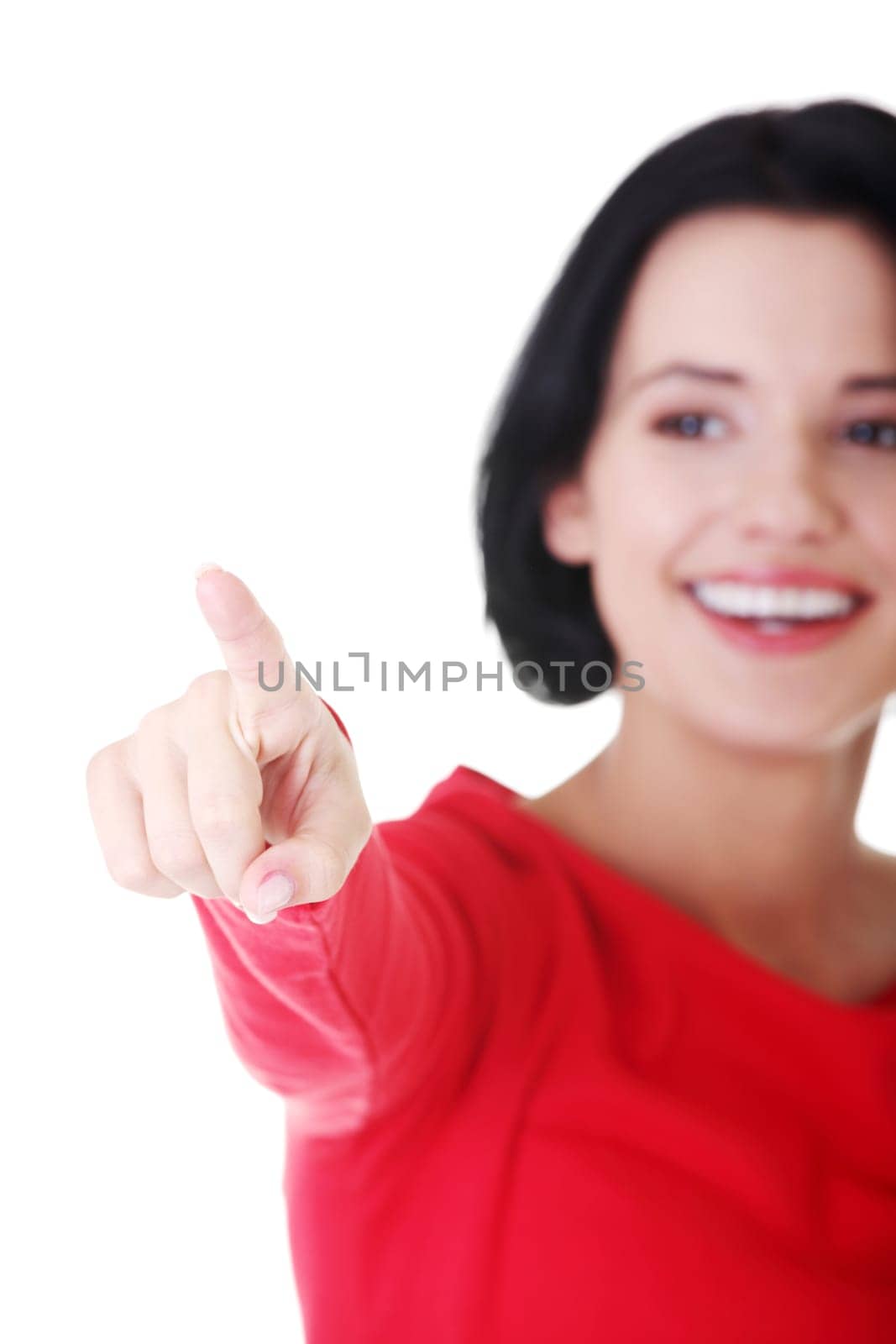 attractive woman in red tshirt pointing up. isolated on white.