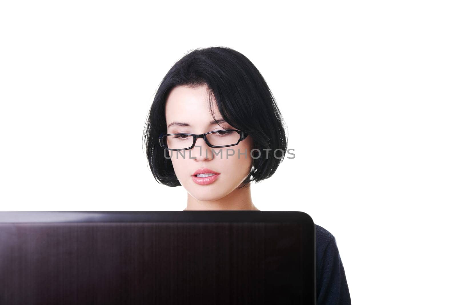attractive young woman sitting in front of a laptop. isolated on white.