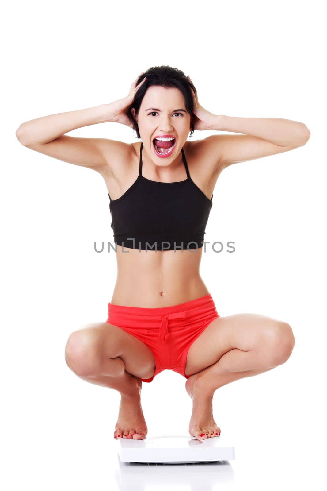 young woman in crouch in sportswear. isolated on white.