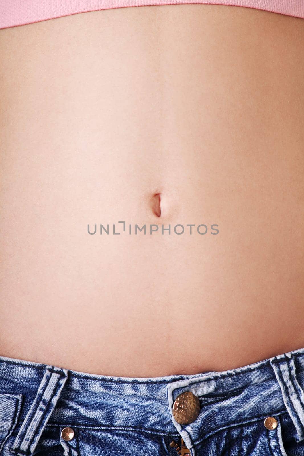 slim fit female's belly. closeup. isolated on white.